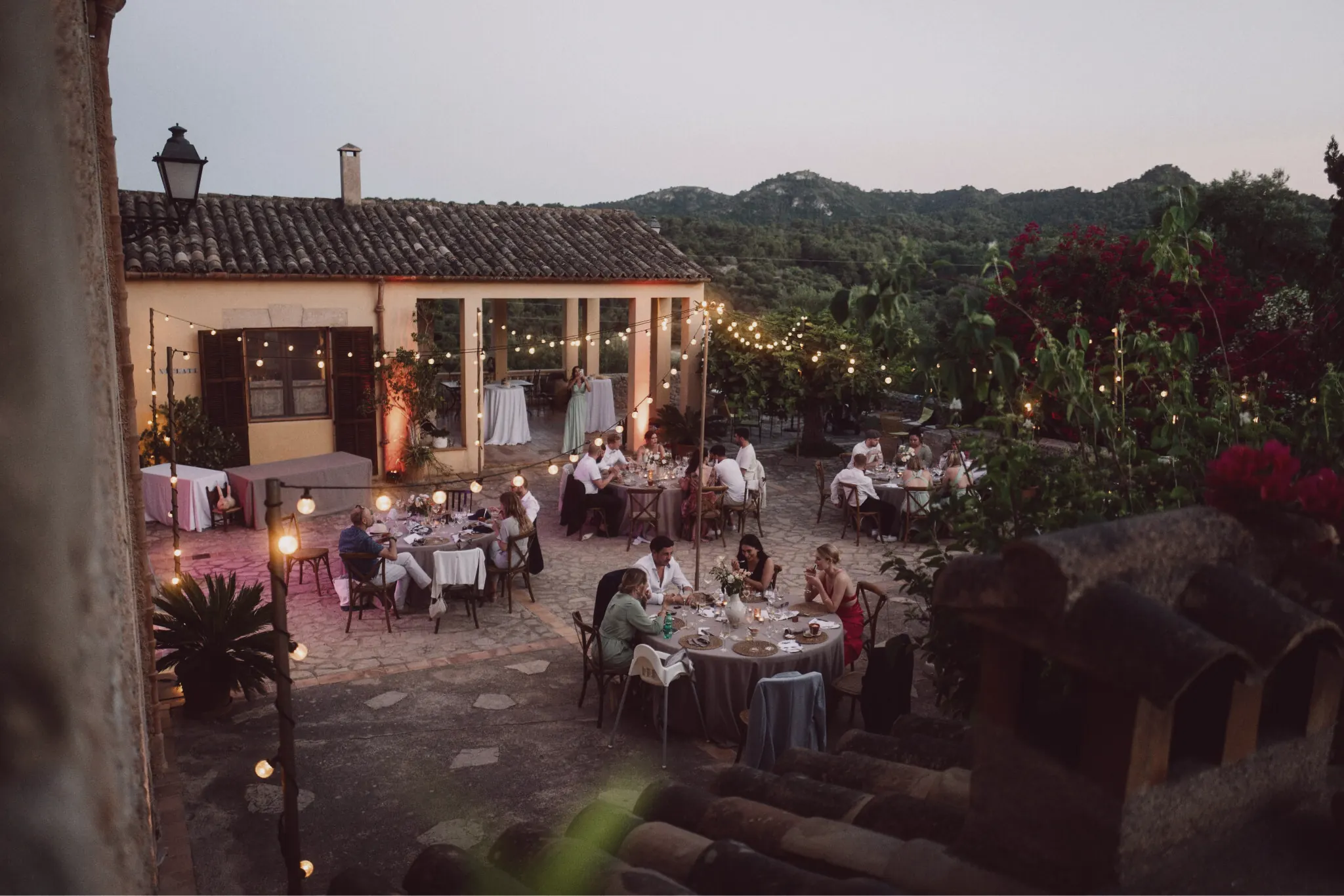 Abendliche Terrasse mit gedeckten Tischen und Lichterketten